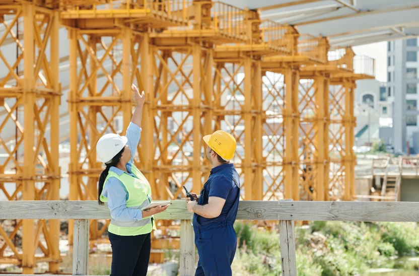 Two people standing in front of a building under construction.