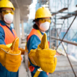 Two construction workers wearing yellow and blue gloves.